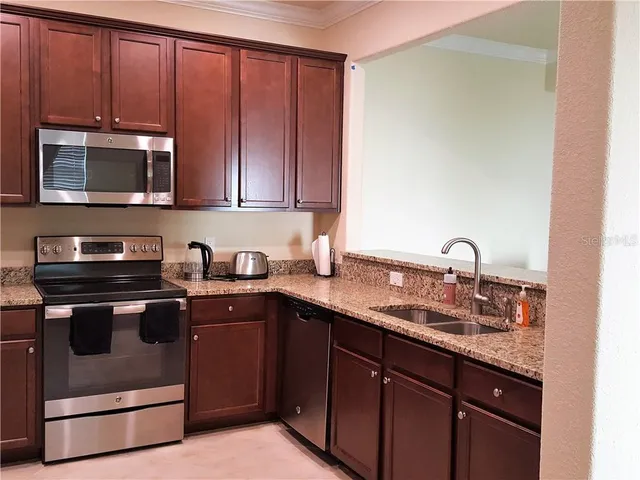 a kitchen with stainless steel appliances granite countertop a sink stove and microwave