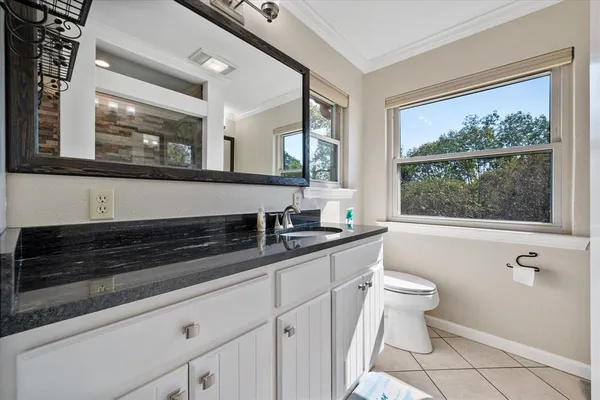 a bathroom with a granite countertop sink a large mirror and a window