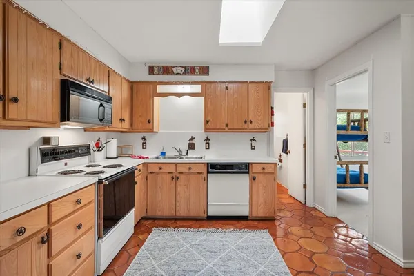 a kitchen with stainless steel appliances granite countertop a sink stove refrigerator and cabinets