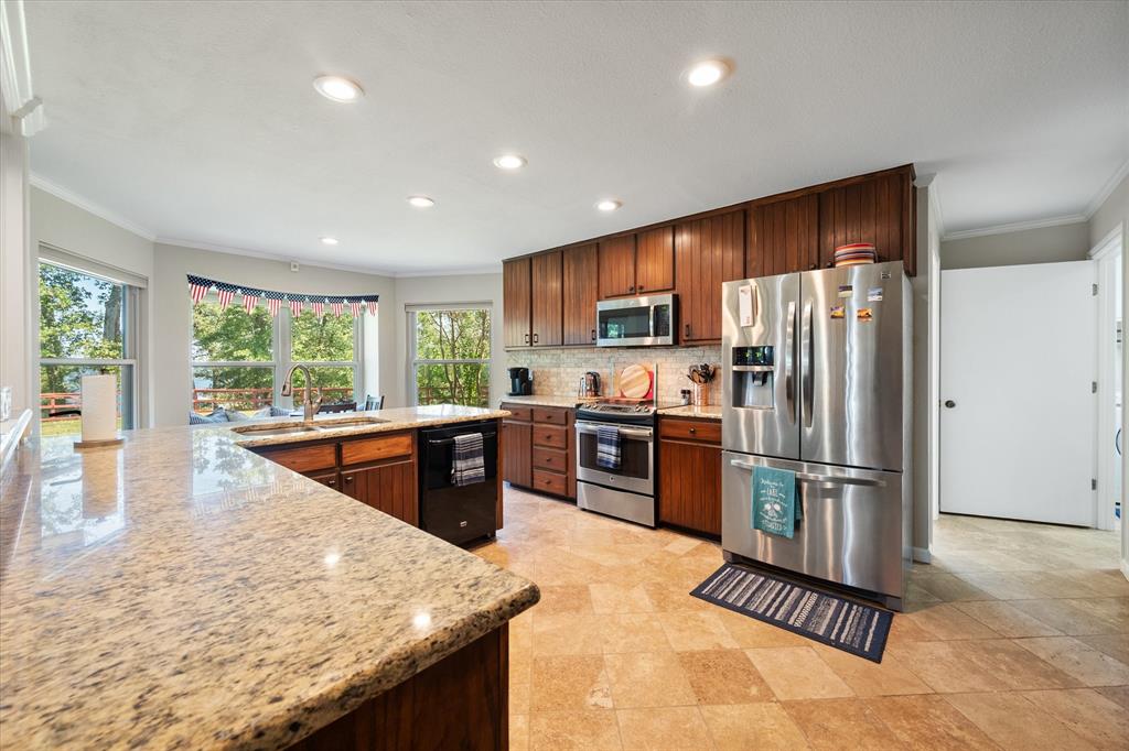 195 Highview Streetman, TX 75859 - Photo 8 of 40 a kitchen with stainless steel appliances granite countertop a refrigerator a stove a sink a dining table and chairs