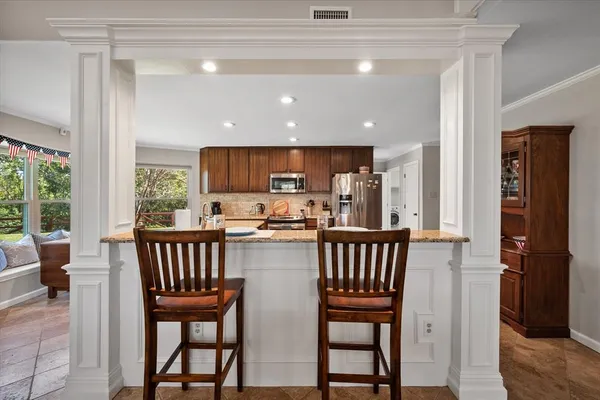 a kitchen with a dining table chairs and entryway
