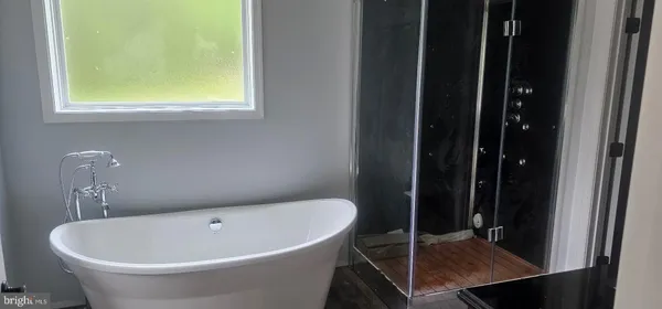 a white bath tub sitting next to a bathroom sink