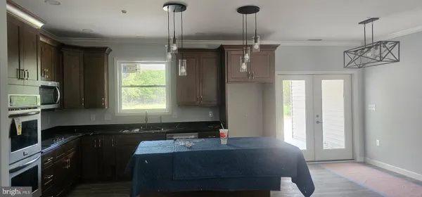 a kitchen with kitchen island a counter top space appliances and a window