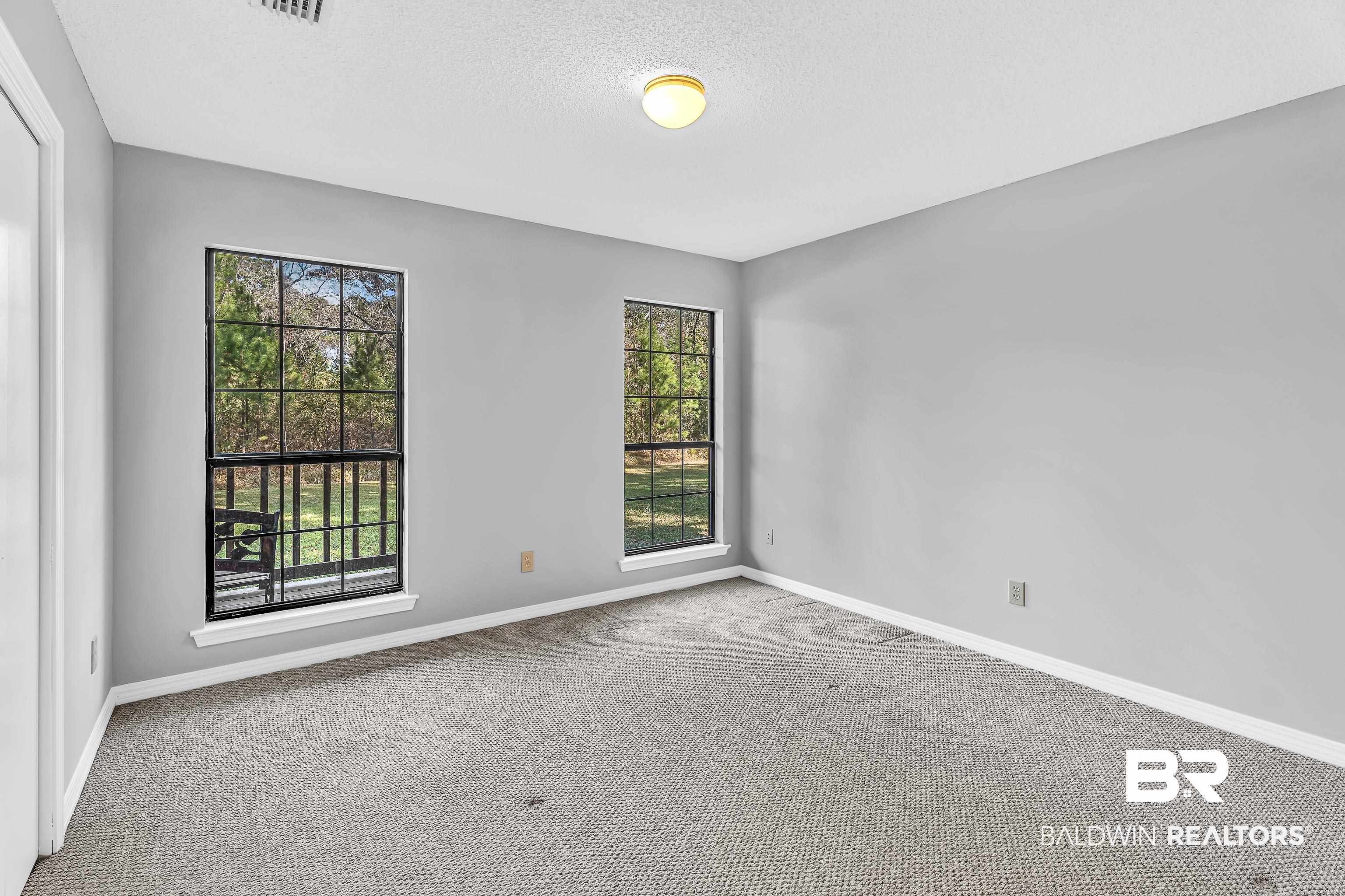 7787 Bellingrath Road Theodore, AL 36582 - Photo 19 of 36 Carpeted empty room with a textured ceiling and baseboards