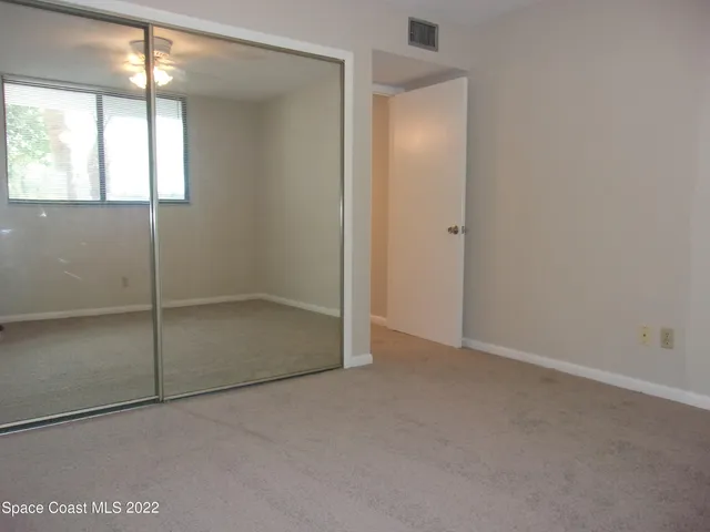 an empty room with windows and closet
