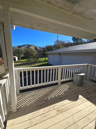 a view of a balcony with wooden floor and fence