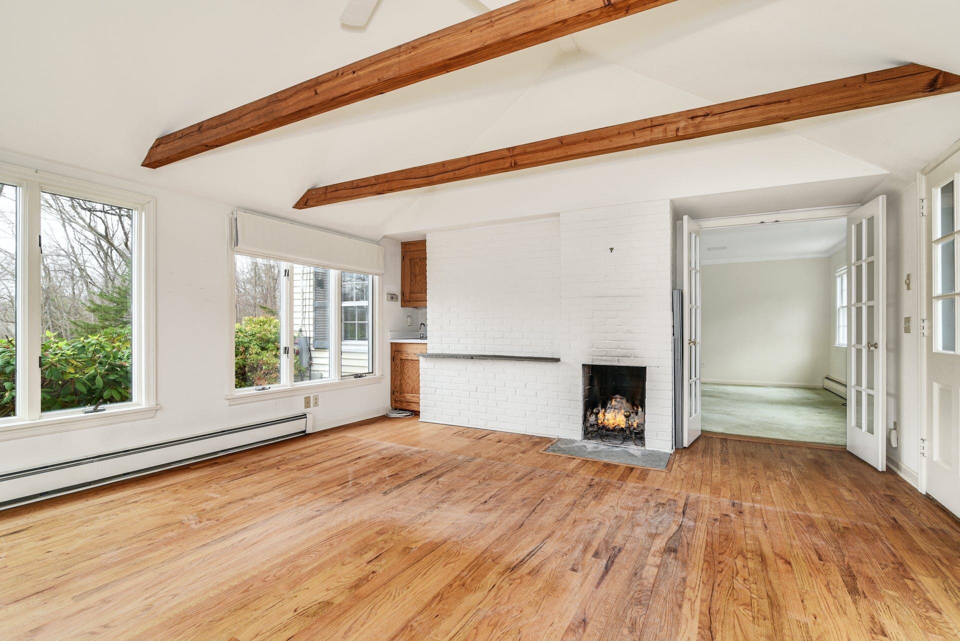 113 Logan Road New Canaan, CT 06840 - Photo 11 of 27 a view of a room with wooden floor and a fireplace