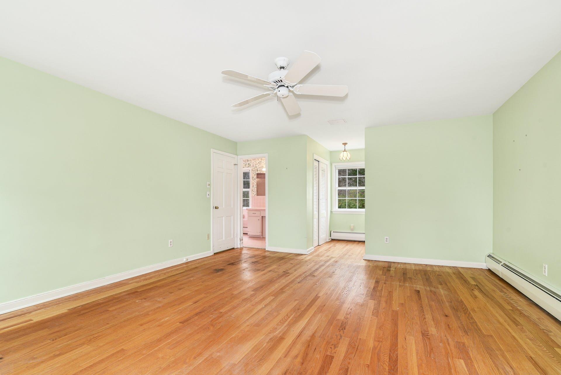 113 Logan Road New Canaan, CT 06840 - Photo 16 of 27 an empty room with wooden floor ceiling fan and windows