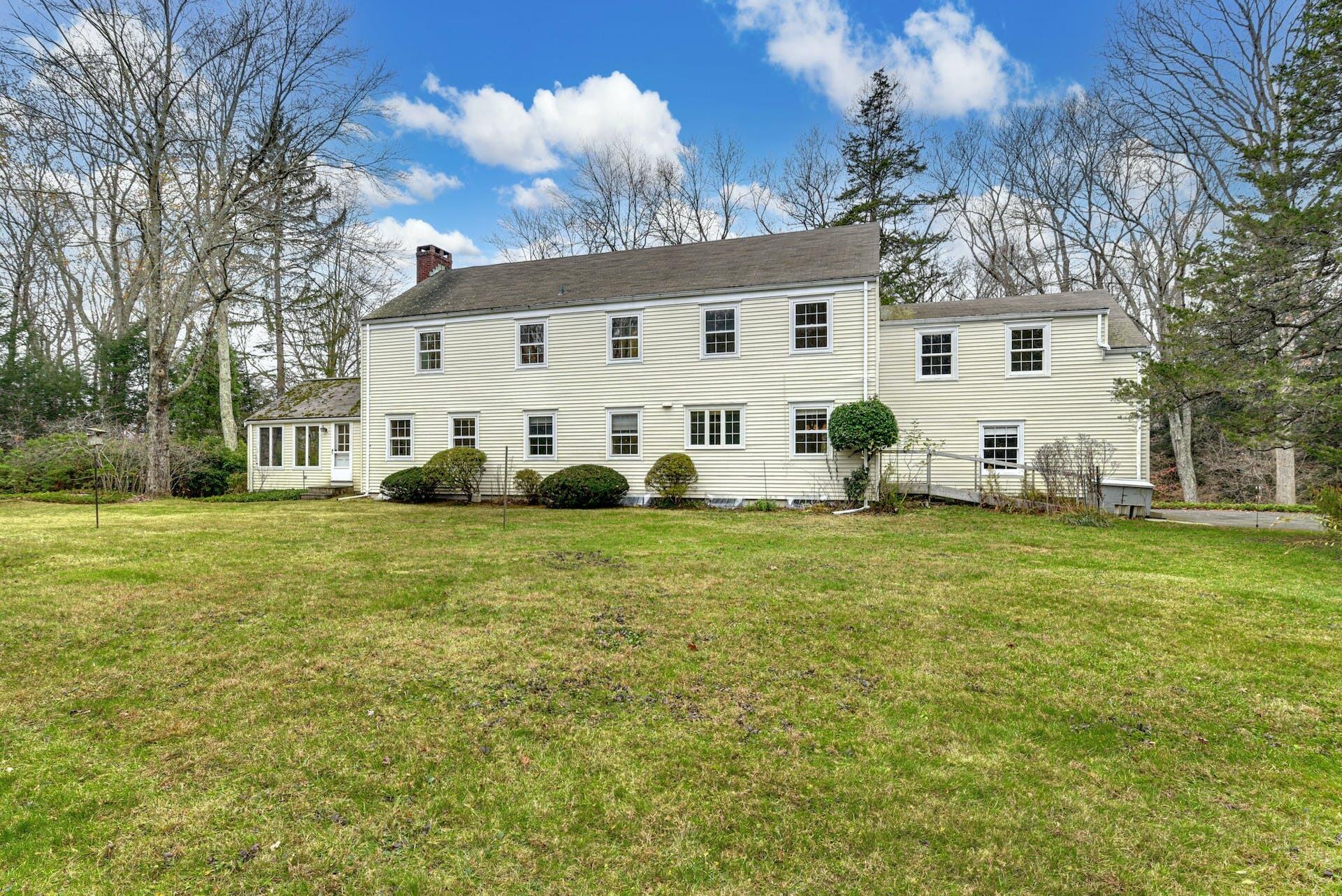 113 Logan Road New Canaan, CT 06840 - Photo 26 of 27 a view of a white house with a yard