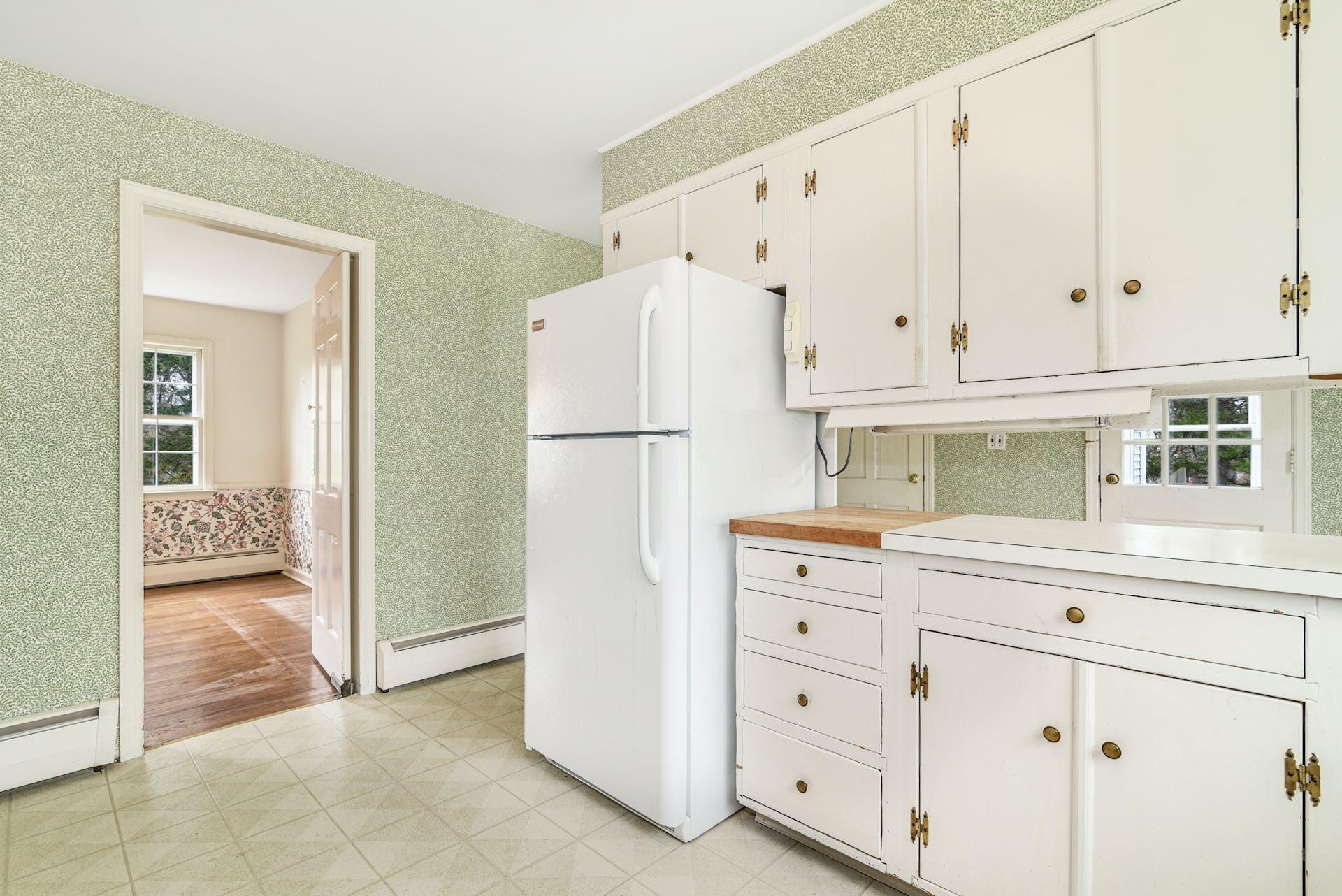 113 Logan Road New Canaan, CT 06840 - Photo 8 of 27 a kitchen with cabinets and a refrigerator