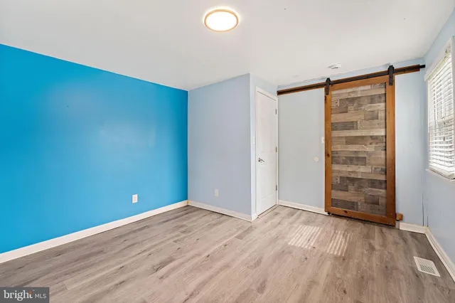 a view of empty room with wooden floor and window