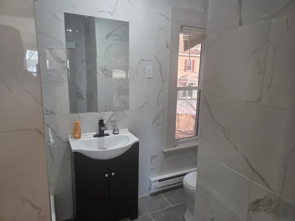 a bathroom with a sink a mirror and window