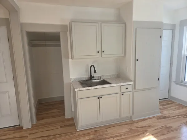 a view of a sink and mirror with wooden floor
