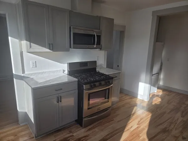 a kitchen with granite countertop a stove and a microwave oven