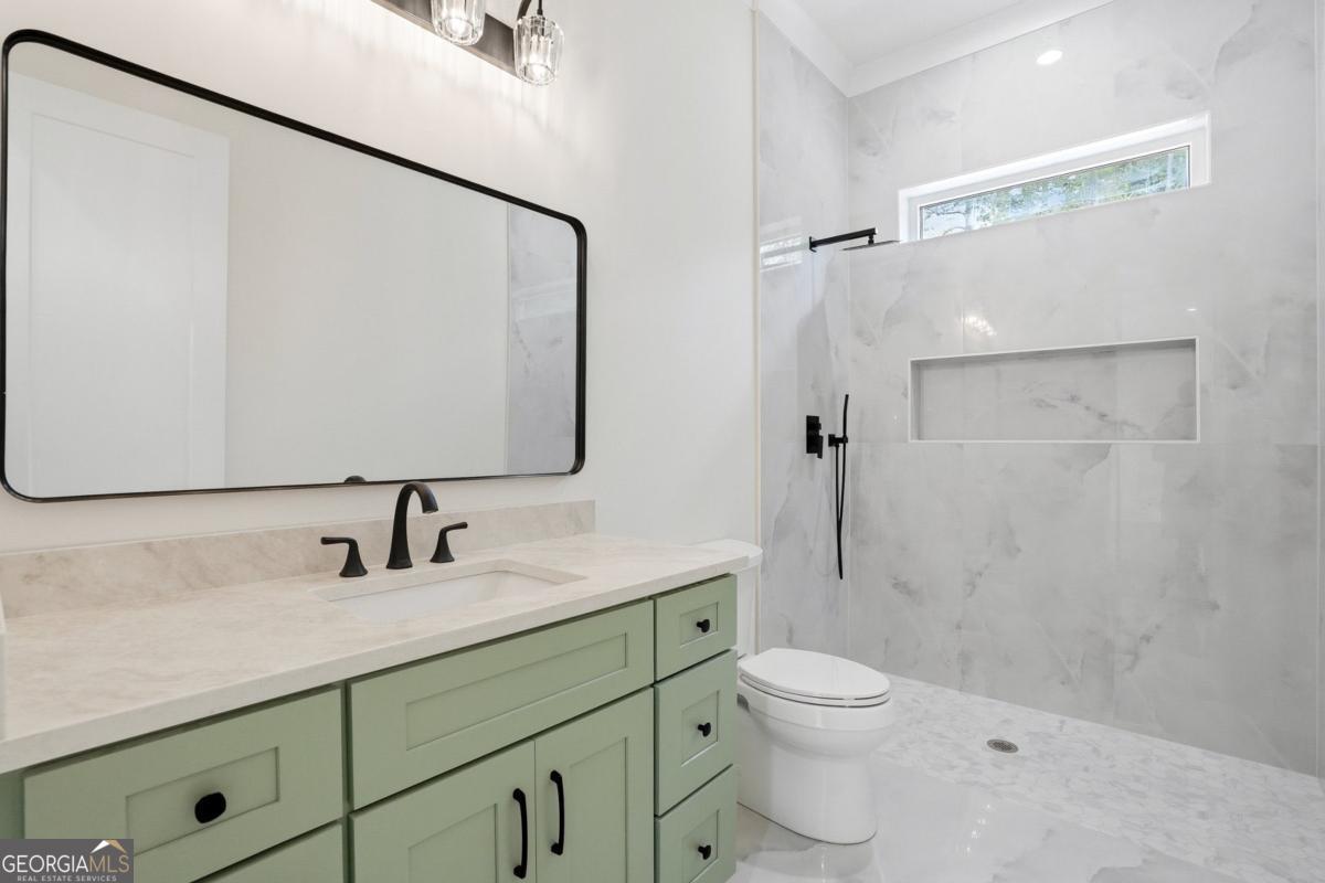 1557 Whitley Road Dacula, GA 30019 - Photo 31 of 46 a bathroom with a granite countertop sink toilet a large mirror a shower and vanity