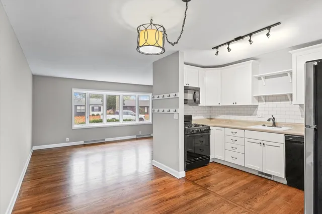 a large kitchen with stainless steel appliances granite countertop a stove and wooden floors