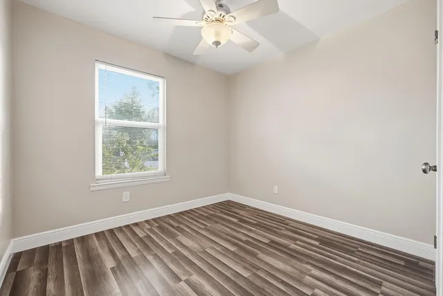 a view of a room with wooden floor and white walls