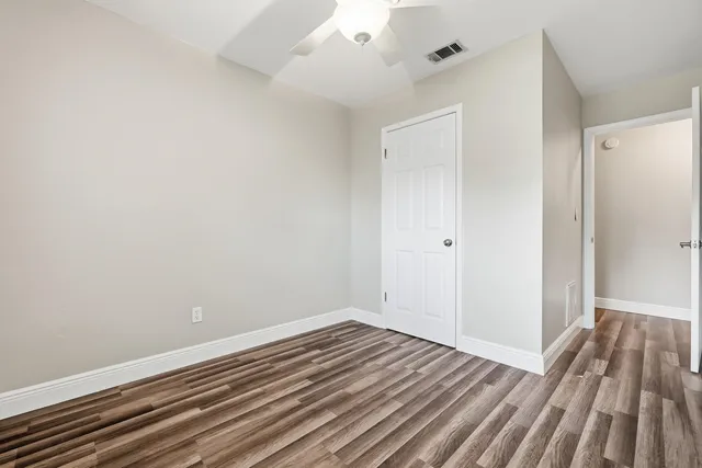 a view of room with window ceiling fan and hardwood floor