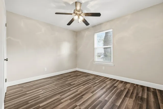 a view of a room with wooden floor and ceiling fan