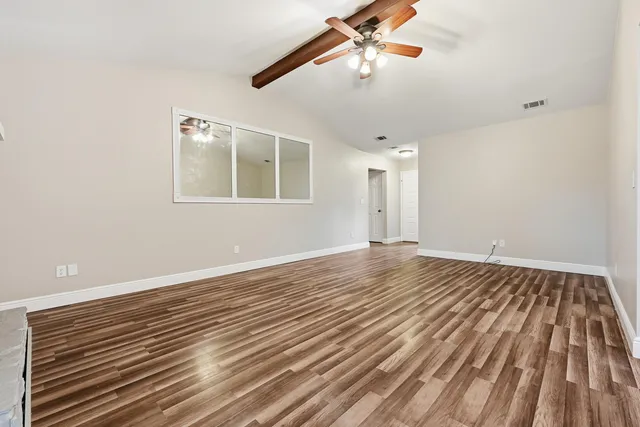 wooden floor in an empty room with a window