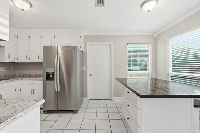 a kitchen with a refrigerator and white cabinets