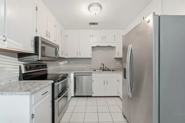 a stove top oven sitting inside of a kitchen