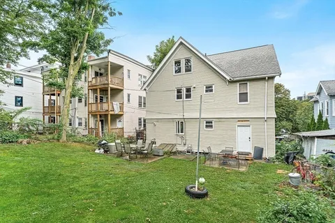 a view of a house with a yard and sitting area