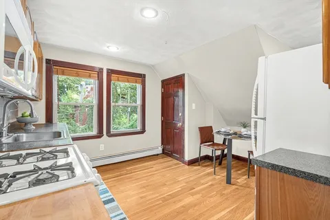 a living room with furniture and a open kitchen view
