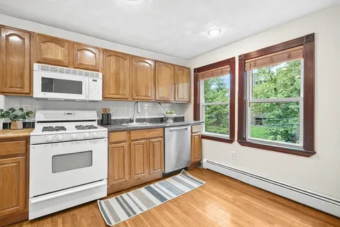 a kitchen with a stove a sink and cabinets
