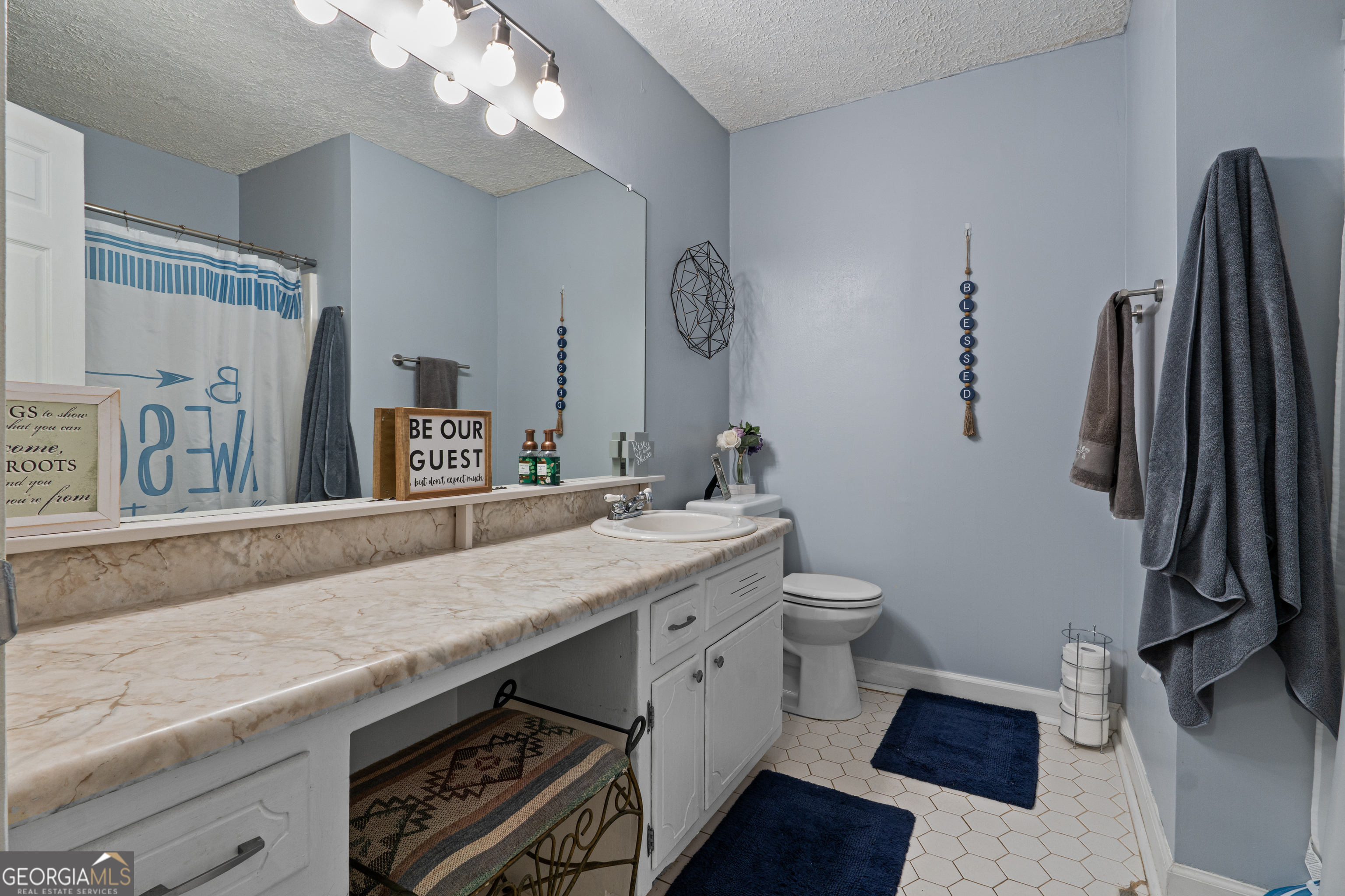 861 Bonner Road Carrollton, GA 30117 - Photo 15 of 38 a bathroom with a granite countertop sink a toilet a mirror and vanity