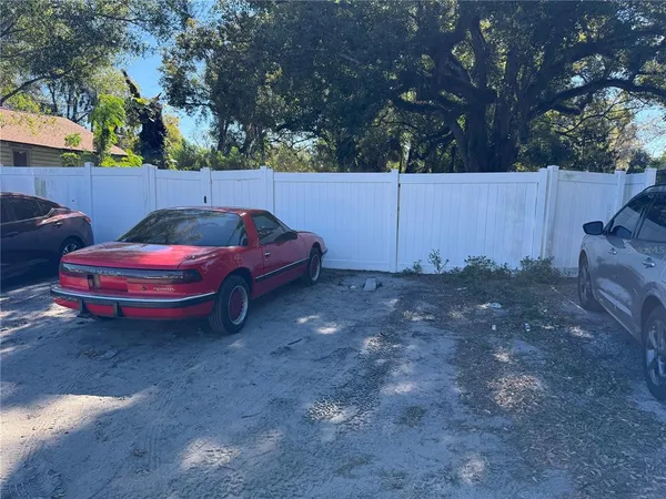 a backyard of a house with barbeque oven and trees