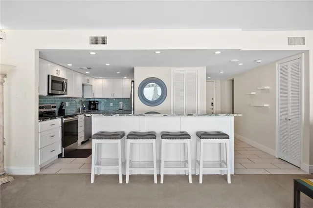 a kitchen with cabinets and chairs