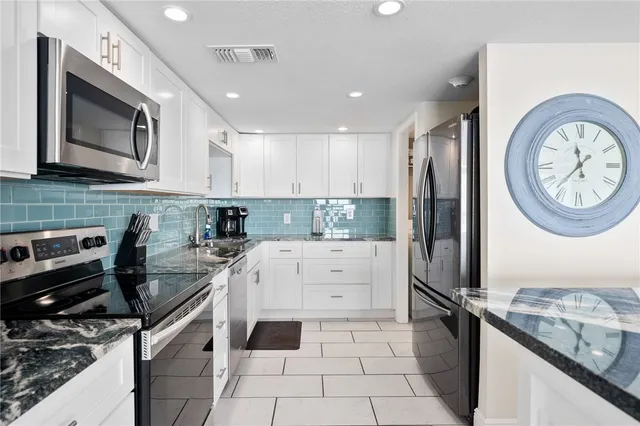a kitchen with a stove a sink and a refrigerator