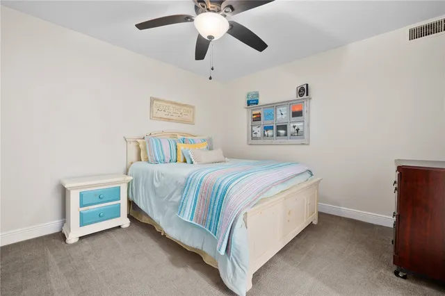 a spacious bedroom with a bed and a ceiling fan