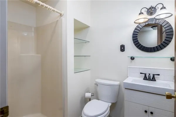 a bathroom with a toilet a sink and mirror