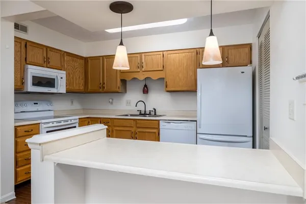 a kitchen with stainless steel appliances granite countertop a sink a stove a refrigerator a microwave oven with white cabinets and granite countertops
