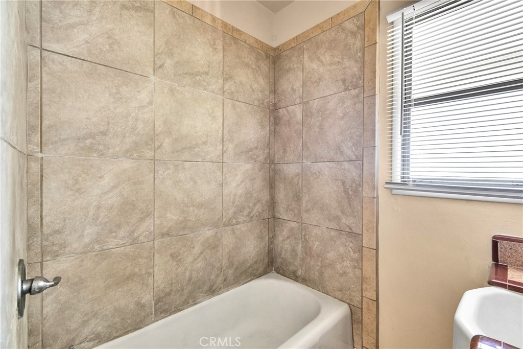 7457 Mt Vernon Street Riverside, CA 92504 - Photo 11 of 16 a bath tub sitting next to a white toilet