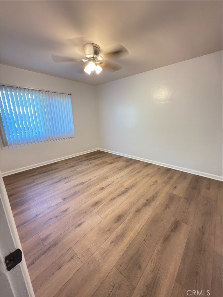 7457 Mt Vernon Street Riverside, CA 92504 - Photo 13 of 16 a view of an empty room with wooden floor and chandelier