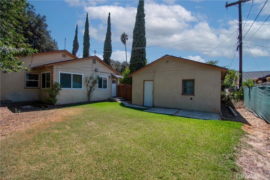7457 Mt Vernon Street Riverside, CA 92504 - Photo 3 of 16 a view of a house with a yard and potted plants