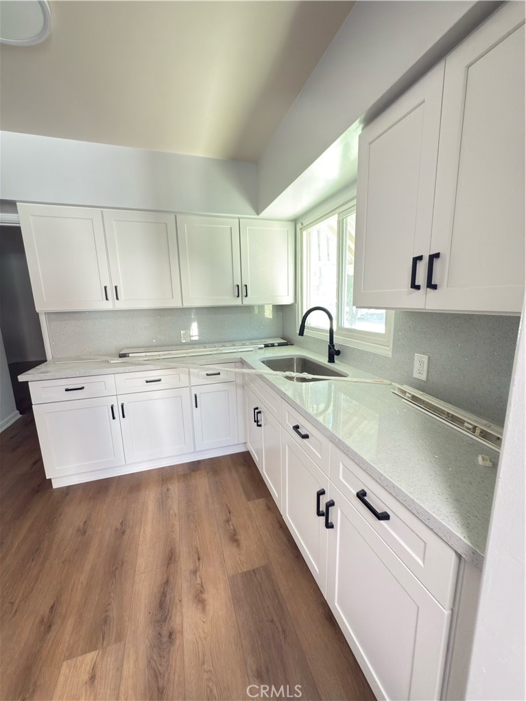 7457 Mt Vernon Street Riverside, CA 92504 - Photo 5 of 16 a large kitchen with granite countertop a sink a counter space and cabinets