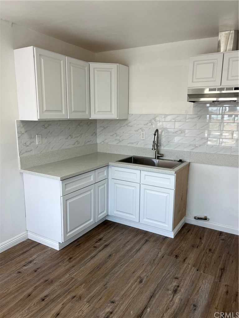 a kitchen with cabinets wooden floor and a sink