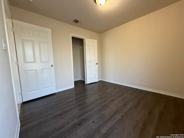 a view of an empty room with wooden floor