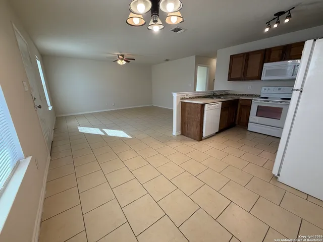 a kitchen with stainless steel appliances a sink a stove a microwave a refrigerator a window