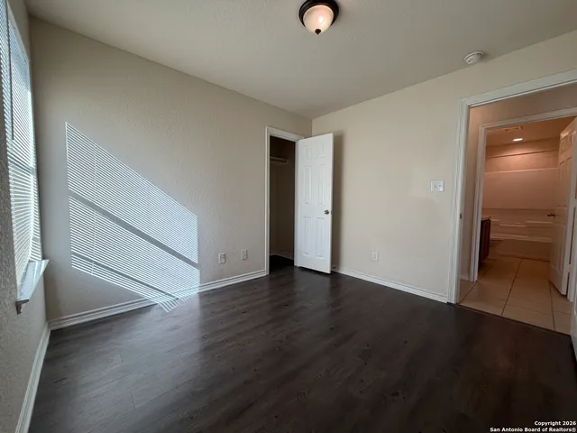 an empty room with wooden floor and closet