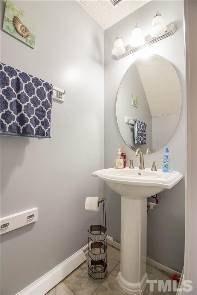 5729 Forest Point Road Raleigh, NC 27610 - Photo 12 of 26 a bathroom with a sink a mirror and vanity