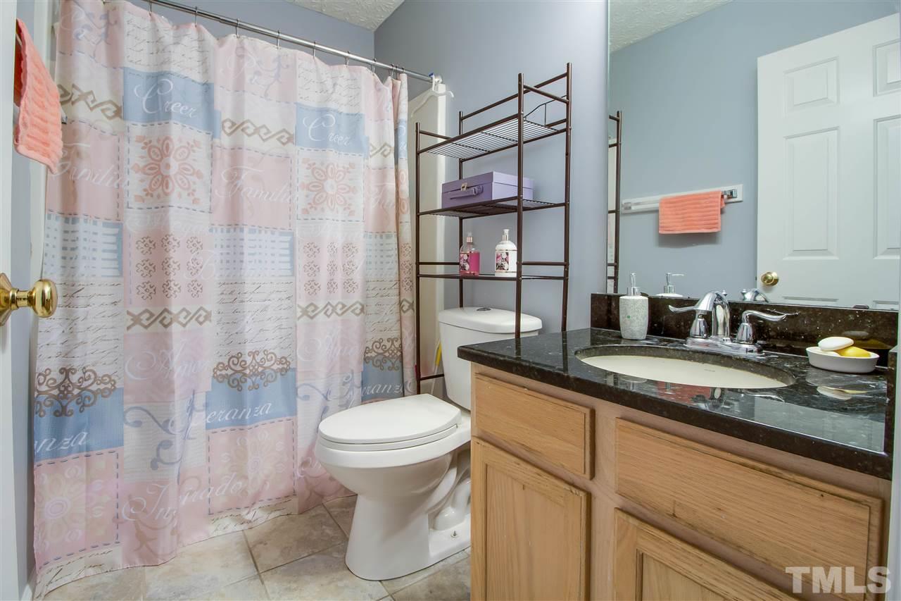 5729 Forest Point Road Raleigh, NC 27610 - Photo 17 of 26 a bathroom with a granite countertop sink a toilet and shower