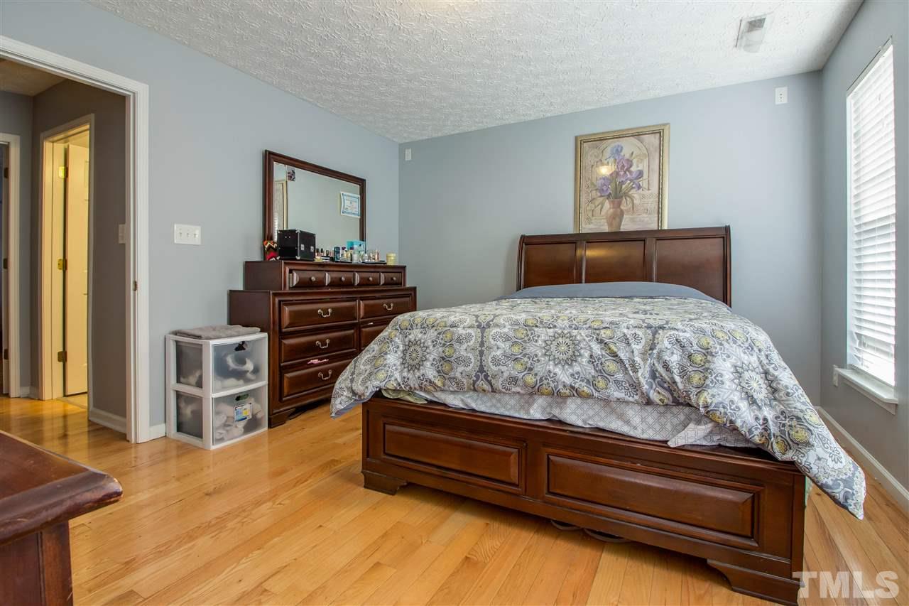 5729 Forest Point Road Raleigh, NC 27610 - Photo 19 of 26 a bedroom with a bed and a dresser