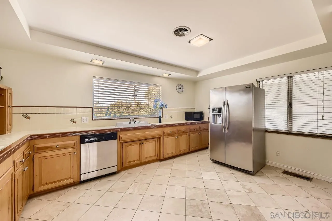 10158 Madrid Way Spring Valley, CA 91977 - Photo 11 of 27 a kitchen with stainless steel appliances granite countertop a refrigerator and a sink