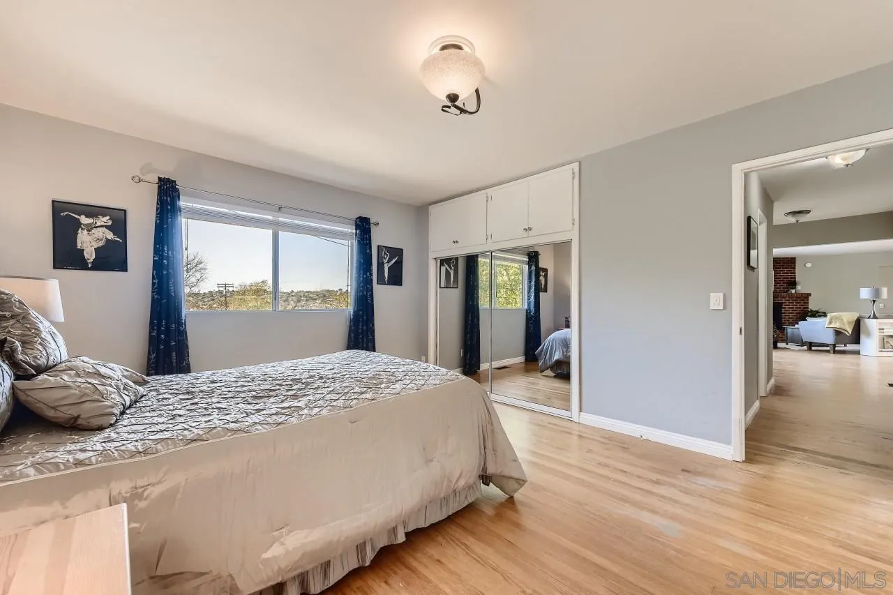 10158 Madrid Way Spring Valley, CA 91977 - Photo 14 of 27 a bedroom with a bed and dresser with wooden floor