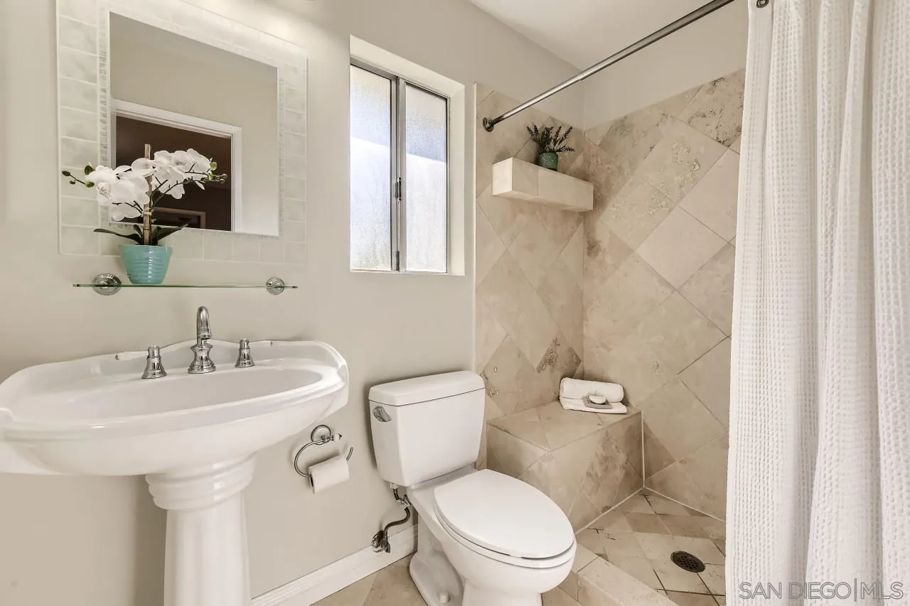 10158 Madrid Way Spring Valley, CA 91977 - Photo 15 of 27 a bathroom with a toilet sink and mirror